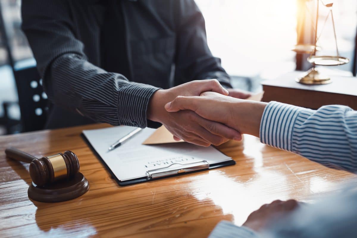 An experienced wrongful death attorney in Alabama shakes hands with a client after agreeing to take on their case.