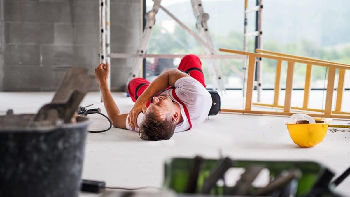 Injured contruction worker laying on floor stock photo