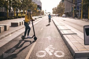 woman riding electric scooter in street