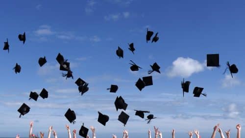 Students tossing their caps at graduation.