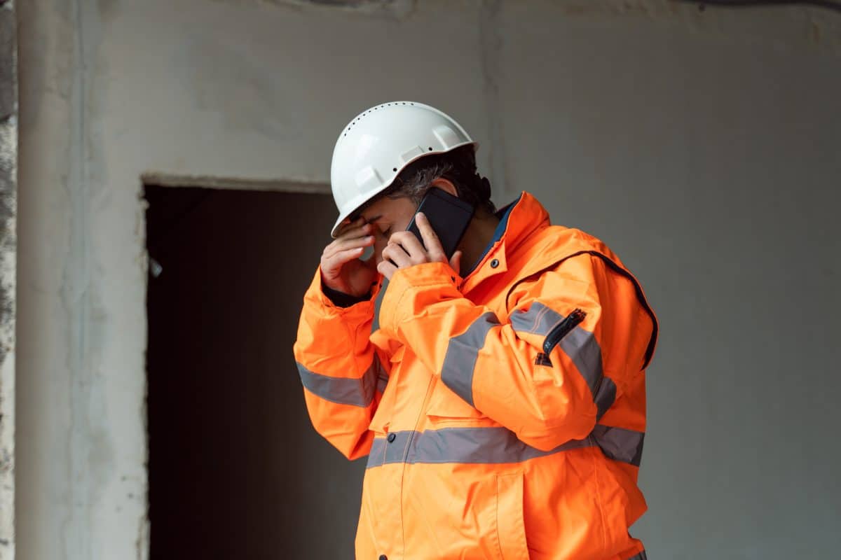 A manual worker on the phone with a workers’ comp attorney. 